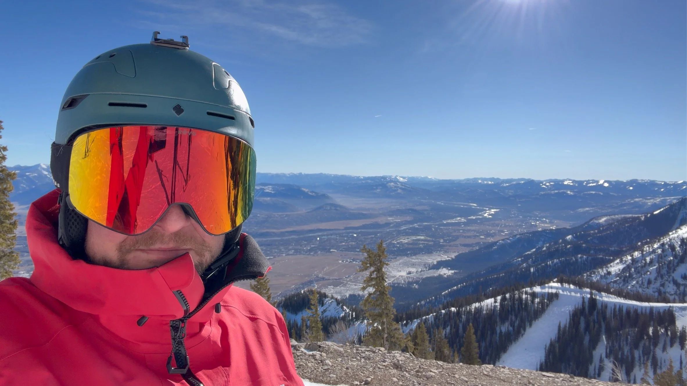 Nick Dawson in ski goggles on a sunny ridge